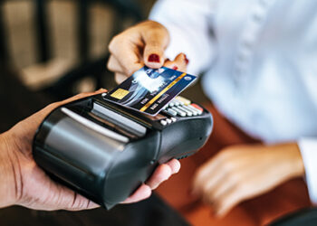 Close-up image of woman paying with credit card in cafe